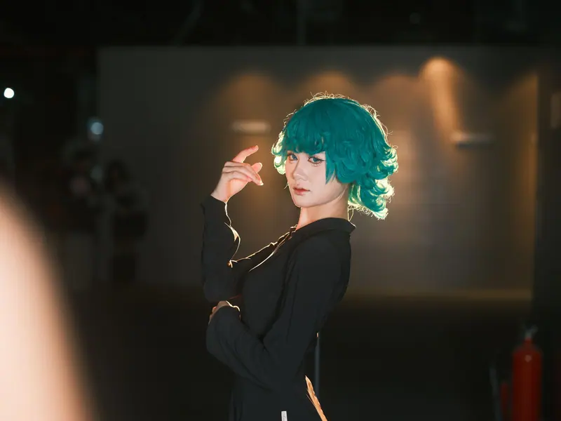 Teal curly bob under stage light