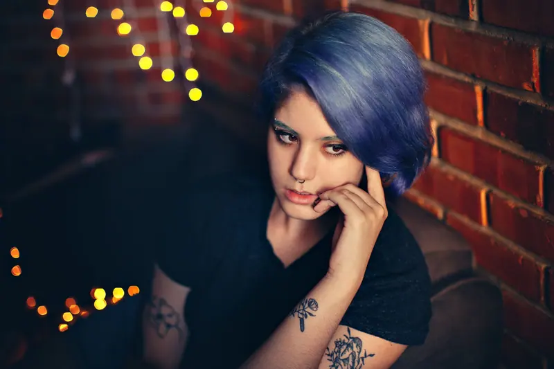 Periwinkle bob against warm brick and string lights