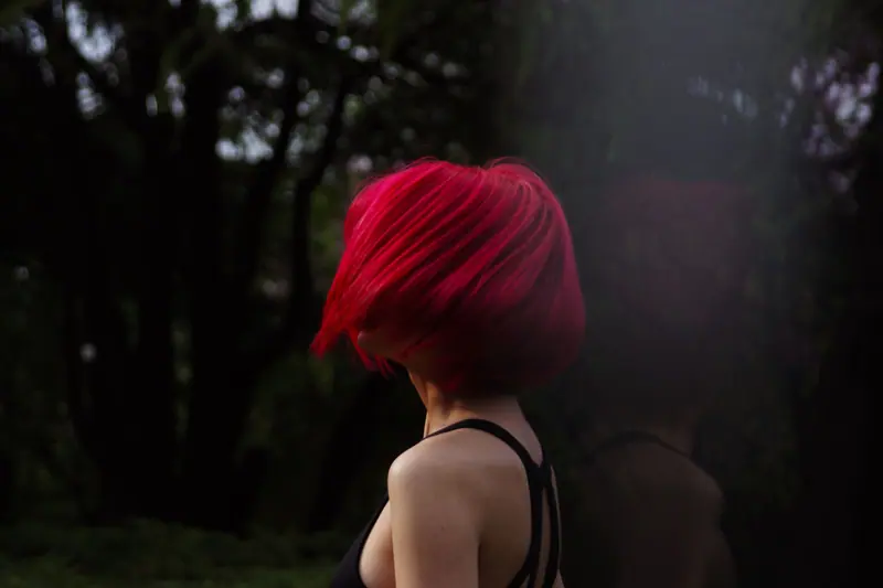 Glossy red bob in a dark garden