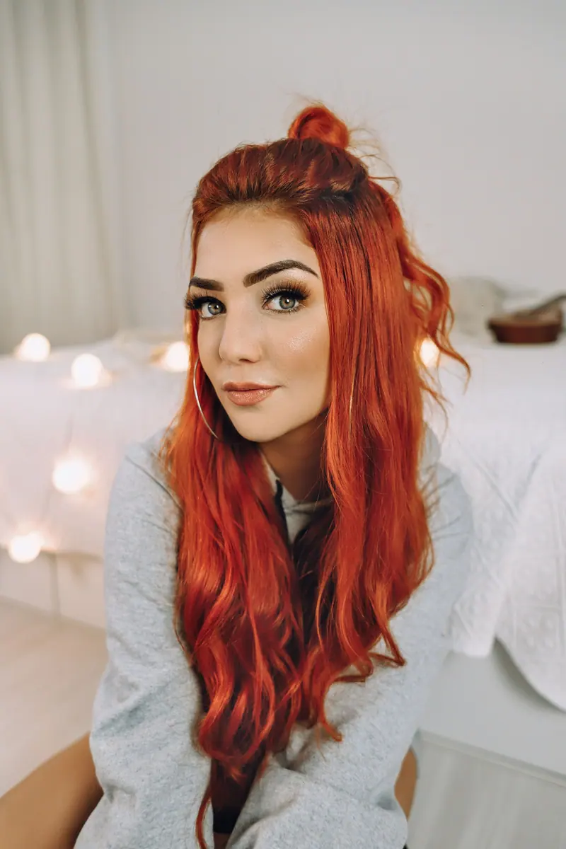 Long cinnamon-red hair in warm indoor light