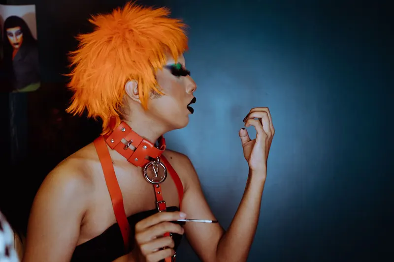 Drag look with a vivid orange wig