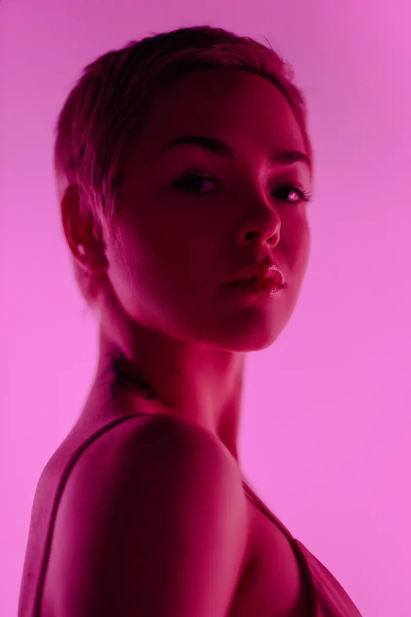 Pixie crop washed in hot-pink light