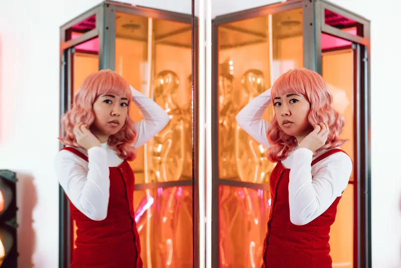 Adjusting a pink wig under ring lights