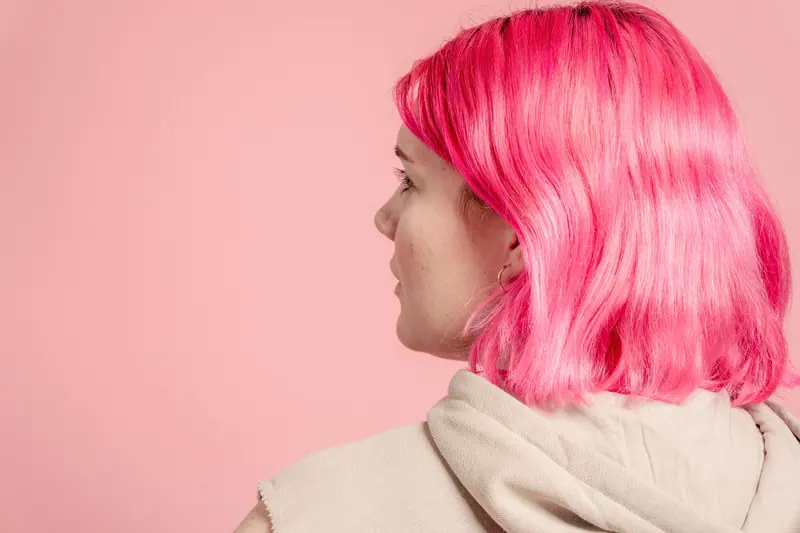Glossy hot-pink lob seen from behind against a pale pink wall