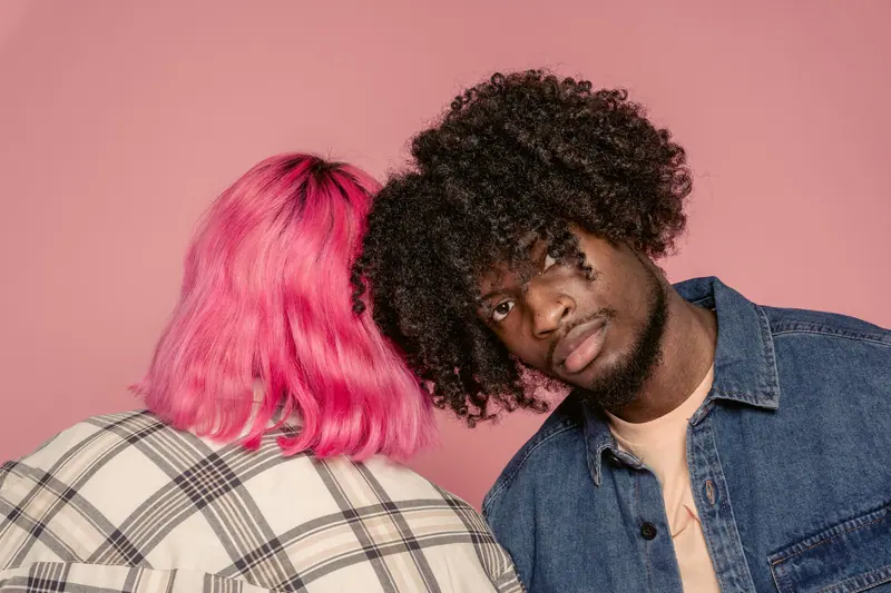 Couple embracing against a pink backdrop