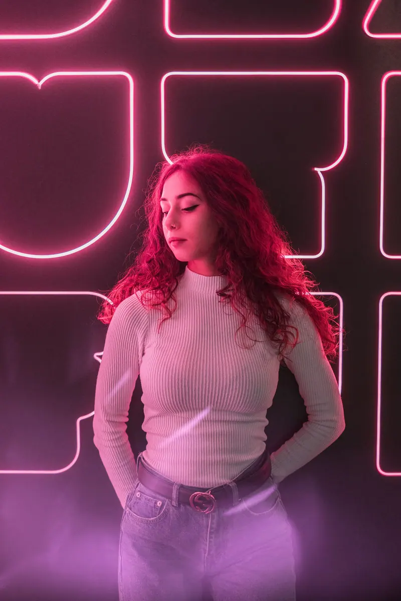 Curls under pink neon signage