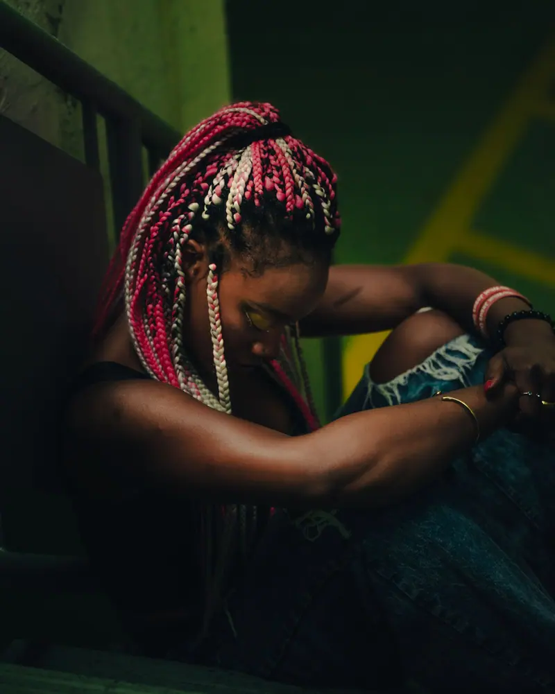 Pink braids in a dim stairwell